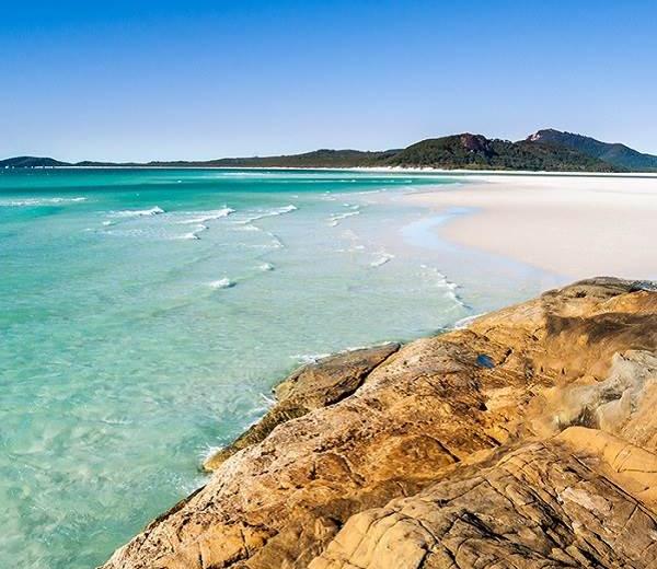 Meer, Strand und Felsen mit einem kleinen Berg - willkommen am Ihana Strand im Reisegebiet Australien und Neuseeland. 